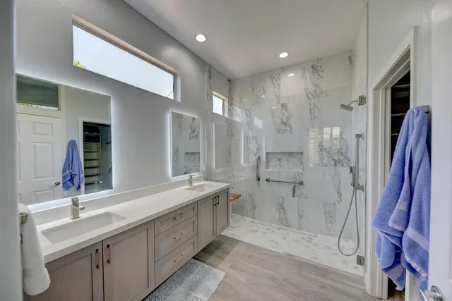 a bathroom with a double vanity sink mirror and shower