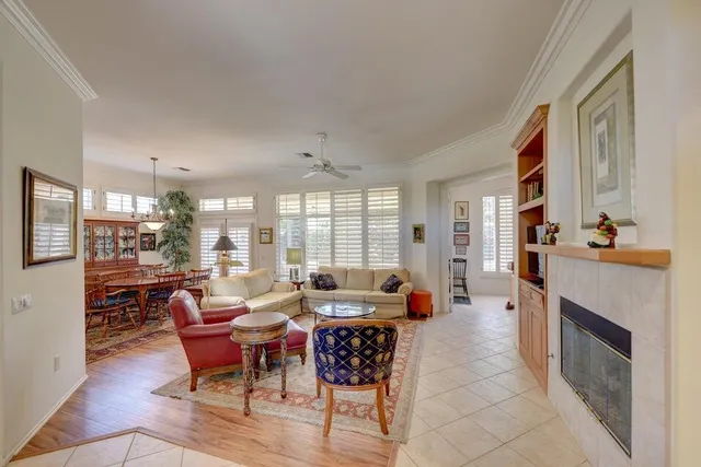 a living room with furniture fireplace and large windows