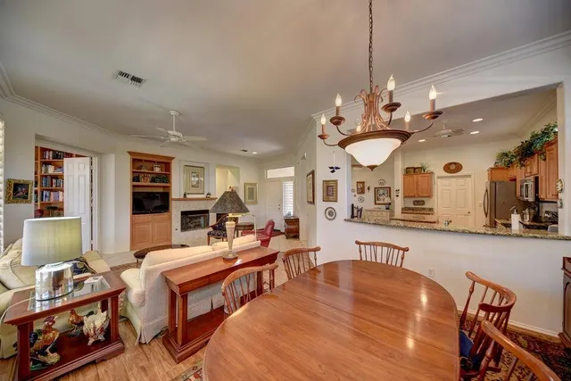 a large living room with stainless steel appliances granite countertop couches a fireplace with wooden floor