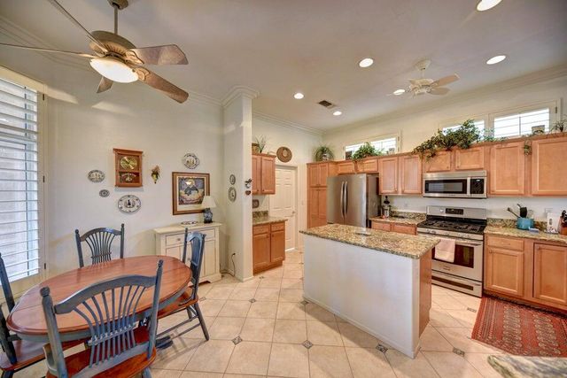a kitchen with stainless steel appliances kitchen island granite countertop a sink and cabinets