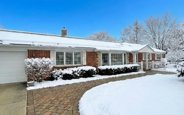 a open kitchen with stainless steel appliances granite countertop a stove top oven a refrigerator with a dining table and chairs with wooden floor