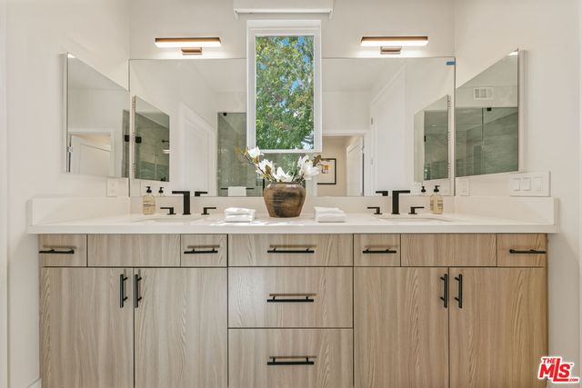 a bathroom with a double vanity sink and mirror
