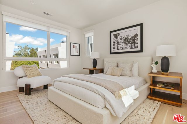 a bedroom with a bed and a large window