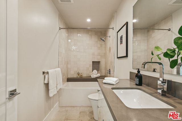 a bathroom with a tub sink and mirror