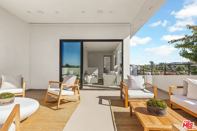 a living room with patio furniture and a large window