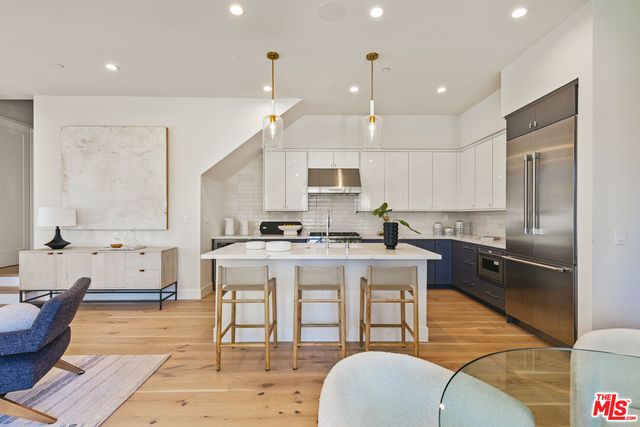 a large kitchen with kitchen island a large counter top space a sink stainless steel appliances and cabinets