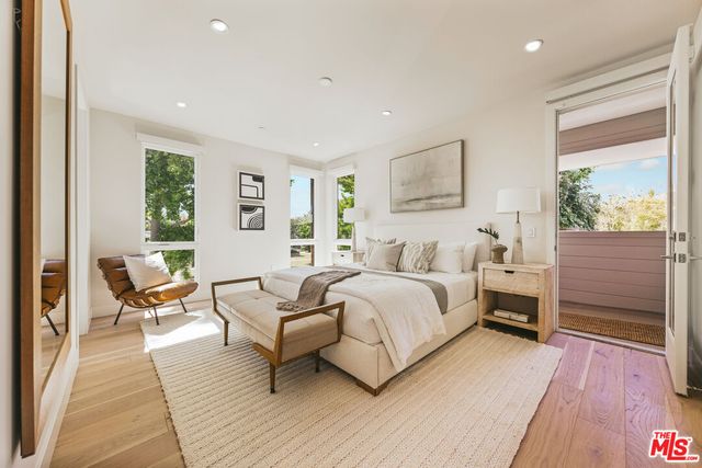 a spacious bedroom with a bed and wooden floor