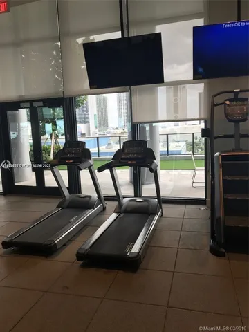 a room with gym equipment and large window