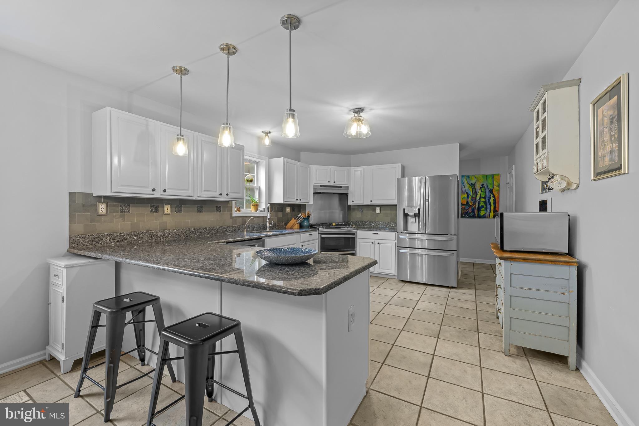 168 Sawmill Road Landenberg, PA 19350 - Photo 14 of 53 a kitchen with stainless steel appliances kitchen island granite countertop a sink a stove a refrigerator and cabinets