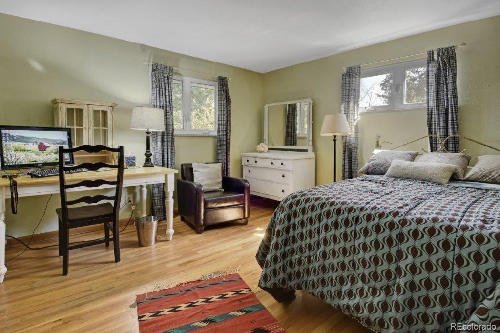 7856 Baseline Road Boulder, CO 80303 - Photo 21 of 40 a bedroom with a bed and wooden floor