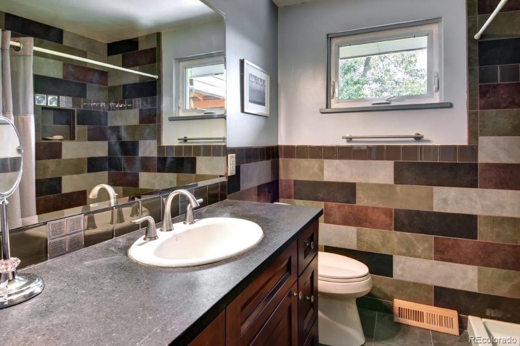 7856 Baseline Road Boulder, CO 80303 - Photo 22 of 40 a bathroom with a sink a toilet a mirror and a shower