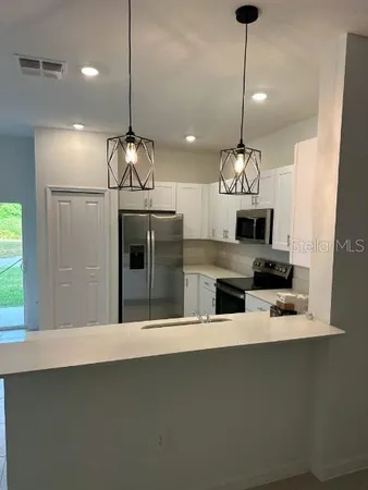 a kitchen with stainless steel appliances a refrigerator sink and stove