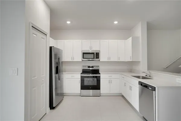 a kitchen with white cabinets stainless steel appliances and sink
