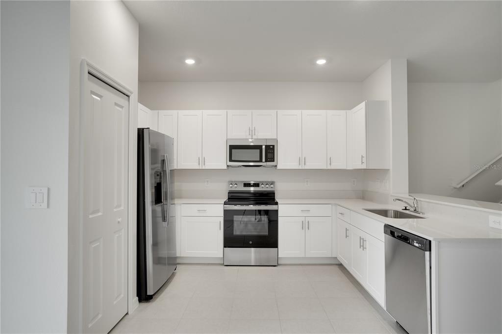 212 27th Street Southeast Ruskin, FL 33570 - Photo 13 of 46 a kitchen with stainless steel appliances white cabinets and a refrigerator