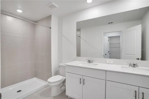 a spacious bathroom with a toilet sink and mirror