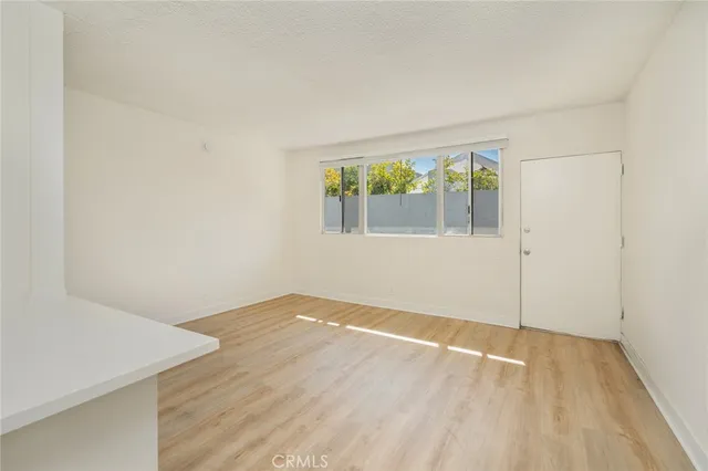 a kitchen with a white cabinets and wooden floor