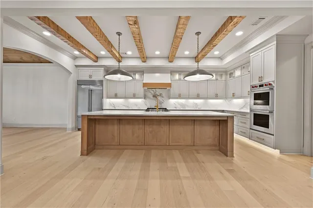 a large kitchen with kitchen island a sink stainless steel appliances and cabinets