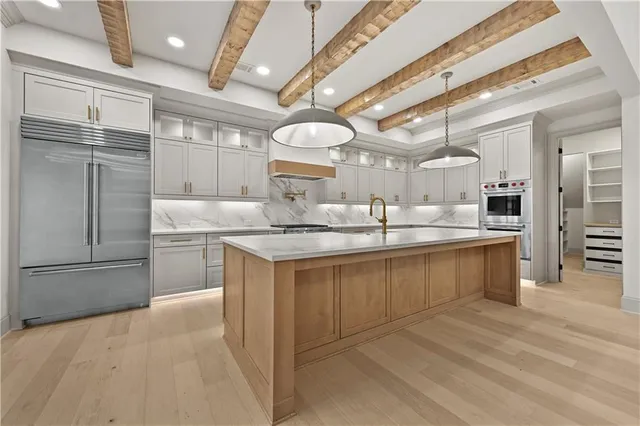 a kitchen with granite countertop a sink cabinets and stainless steel appliances