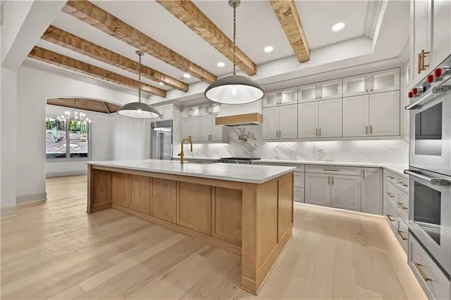 a large kitchen with stainless steel appliances granite countertop a lot of counter space and a sink