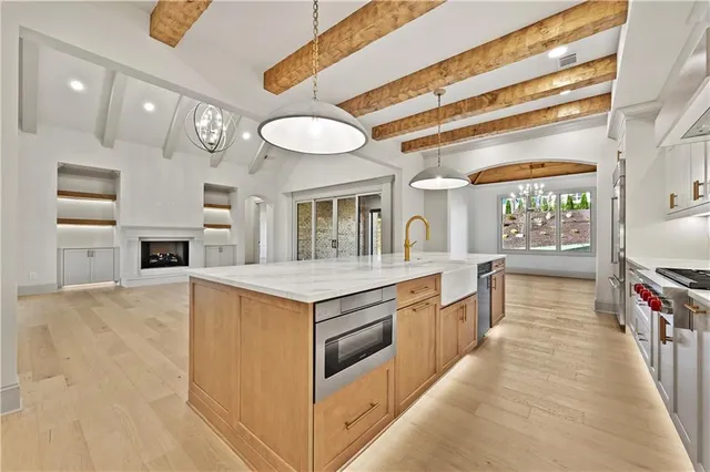 a view of a chandelier in big room with windows and chandelier