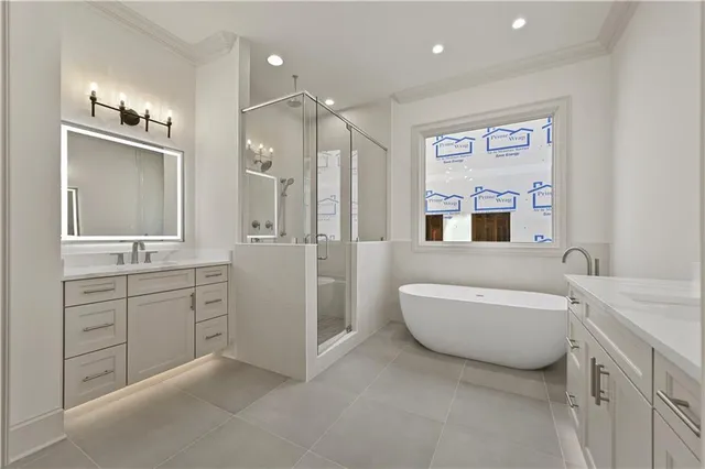 a spacious bathroom with a double vanity sink a large mirror a bathtub and window