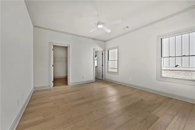 an empty room with windows and ceiling fan