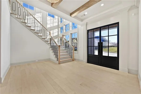 a view of an empty room with stairs and a window