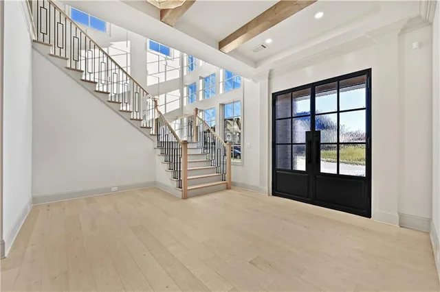 a view of an empty room with stairs and a window