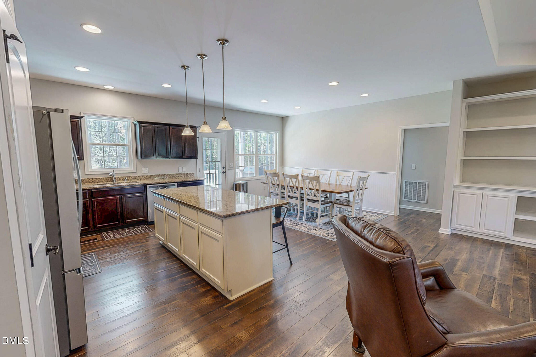 2223 Holeman Ashley Road Timberlake, NC 27583 - Photo 29 of 42 a kitchen with stainless steel appliances granite countertop a stove top oven a sink dishwasher a dining table and chairs with wooden floor