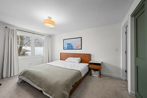 a bedroom with a bed and painting on the wall