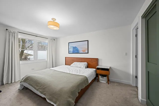 a bedroom with a bed and painting on the wall