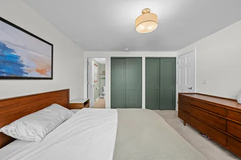 a bedroom with a large bed and a chandelier