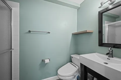 a bathroom with a toilet a sink and mirror