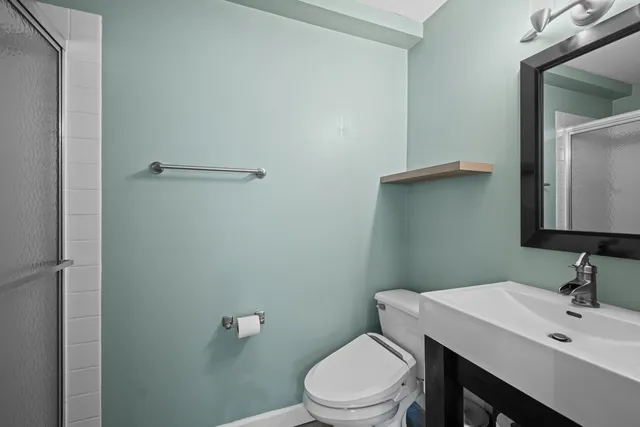 a bathroom with a toilet a sink and mirror