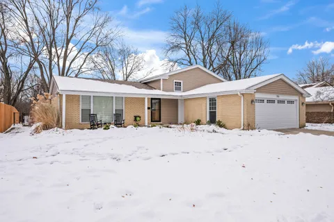 a view of a house with a yard covered in snow