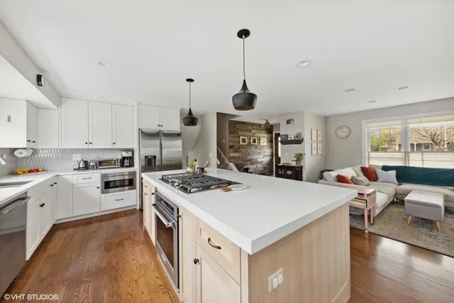 a kitchen with a stove a sink a dining table and chairs