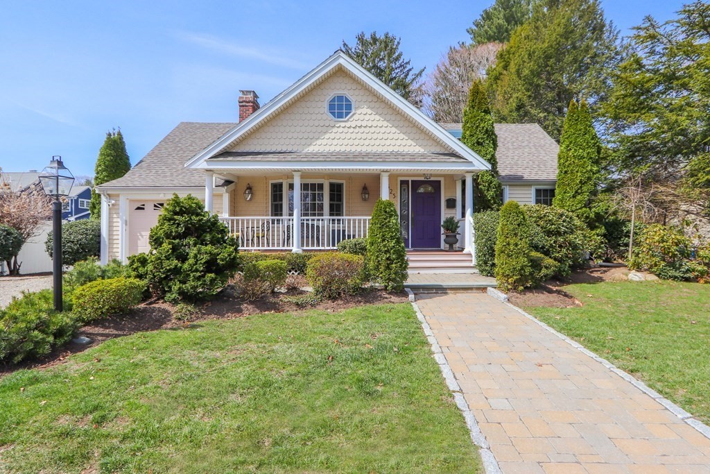 a front view of a house with a yard and trees