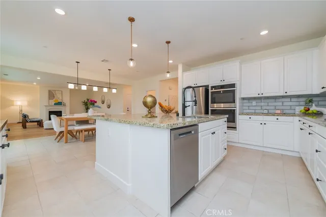 a large white kitchen with lots of counter space dining table and chairs
