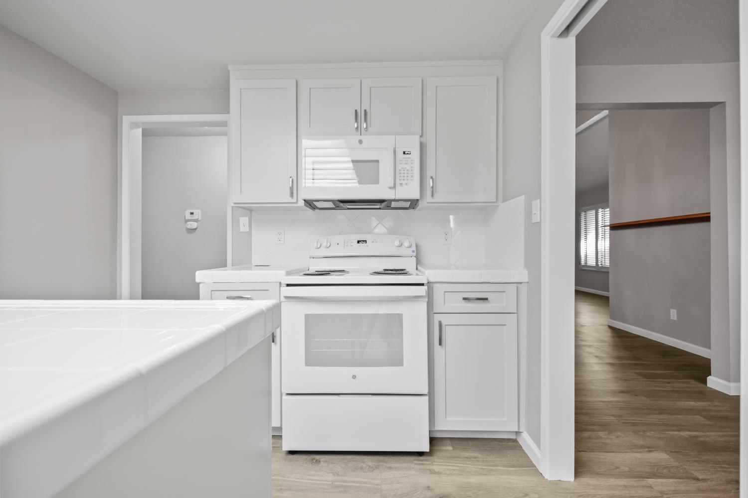 1001 West Lincoln Road, Unit A Stockton, CA 95207 - Photo 11 of 32 a kitchen with white cabinets and white appliances