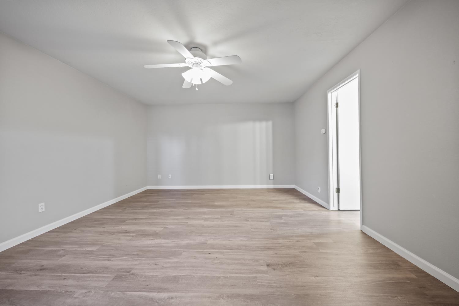 1001 West Lincoln Road, Unit A Stockton, CA 95207 - Photo 18 of 32 a view of an empty room with wooden floor and a window