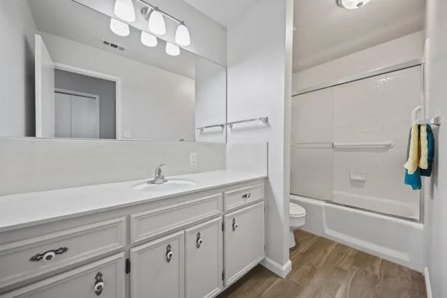 a bathroom with a sink a toilet and shower