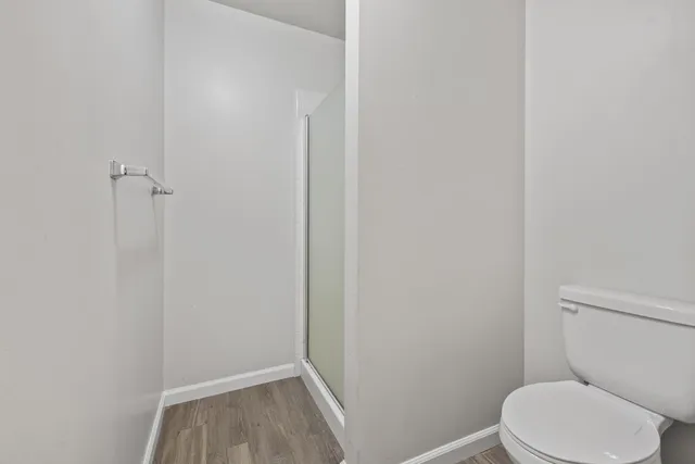 a white toilet sitting next to a shower