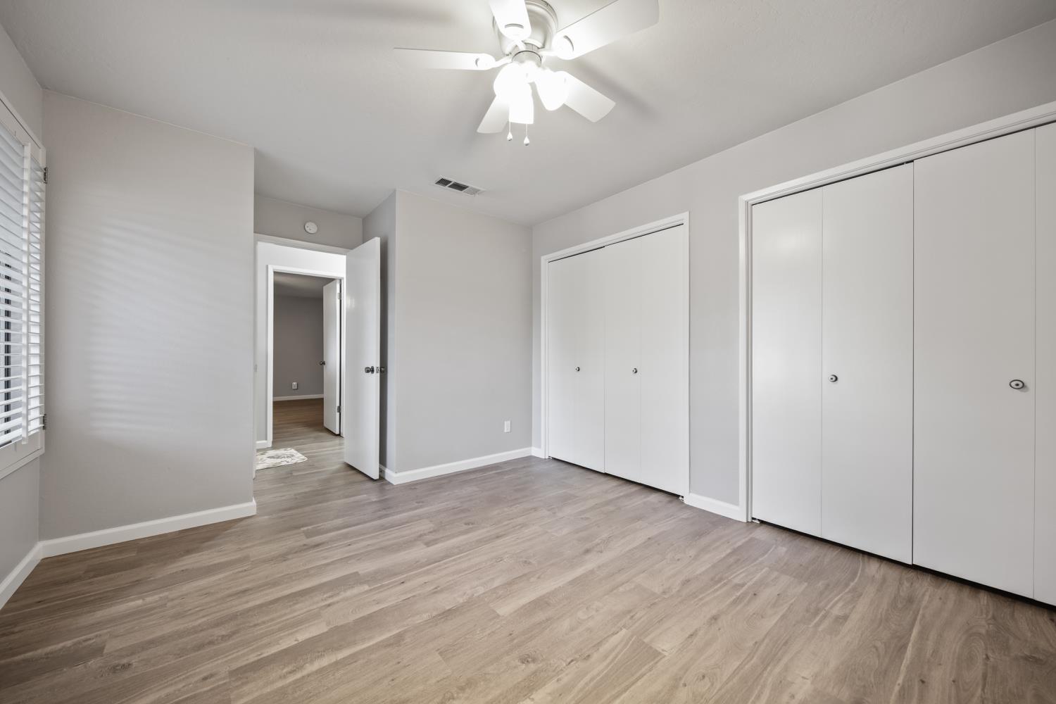1001 West Lincoln Road, Unit A Stockton, CA 95207 - Photo 23 of 32 a view of an empty room with wooden floor and a ceiling fan