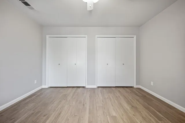 a view of an empty room with wooden floor