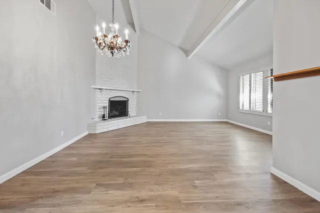 wooden floor chandelier and windows in an empty room
