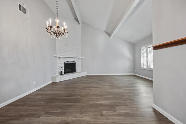 a view of a room with a fireplace chandelier and wooden floor