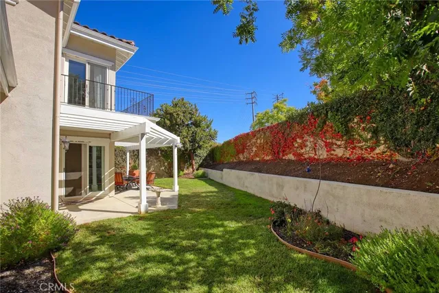 a view of a house with backyard and sitting area