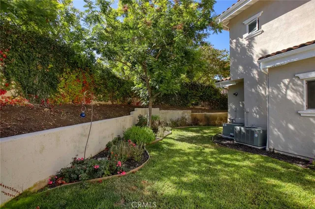 a view of a backyard with potted plants and large trees