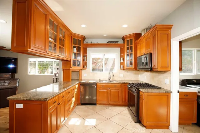 a kitchen with stainless steel appliances granite countertop a sink and cabinets