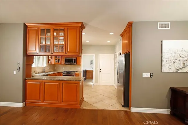 a kitchen with stainless steel appliances granite countertop a refrigerator and a stove top oven